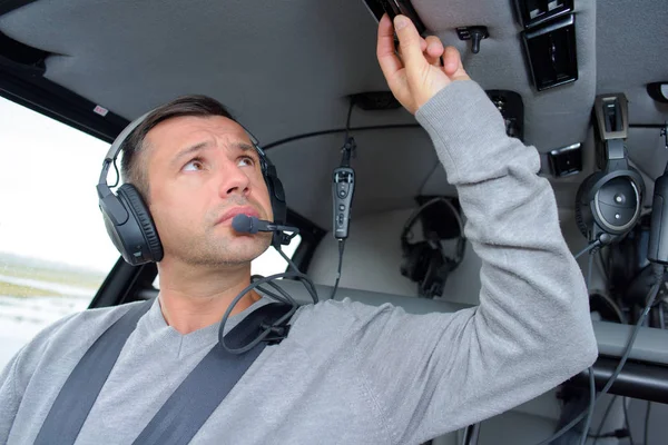 Pilot adjusting overhead controls — Stock Photo, Image