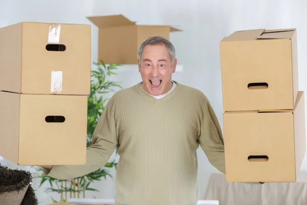Silných zralý muž nesoucí krabice během stěhování — Stock fotografie