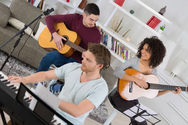 Três jovens tocando instrumentos musicais — Fotografia de Stock