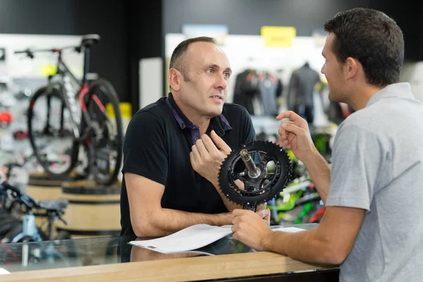 バイク屋で部品を買っている男性 — ストック写真