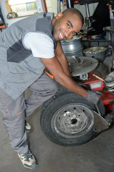 Uomo che rimuove il pneumatico dalla ruota — Foto Stock