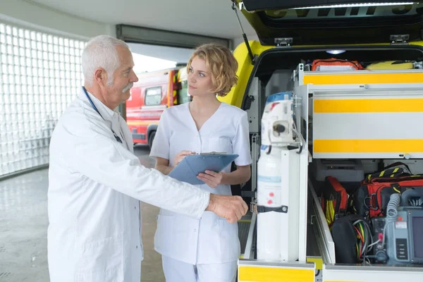 Medico di emergenza e infermiere in piedi davanti all'ambulanza — Foto Stock
