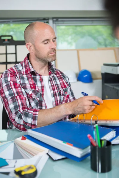 Arbeiter erledigt Papierkram in seinem Büro — Stockfoto