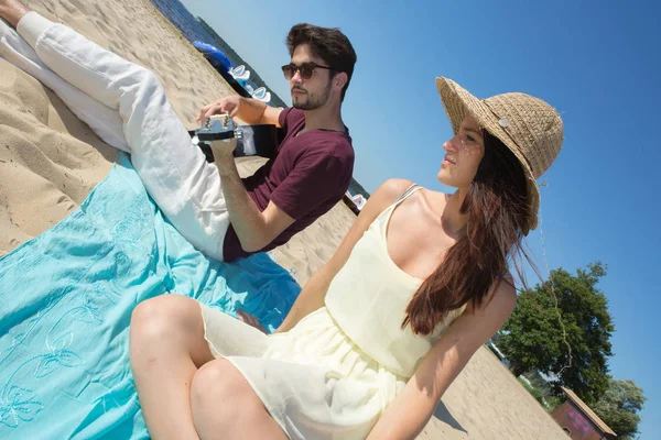 Ung man med gitarr och flickvän på stranden — Stockfoto