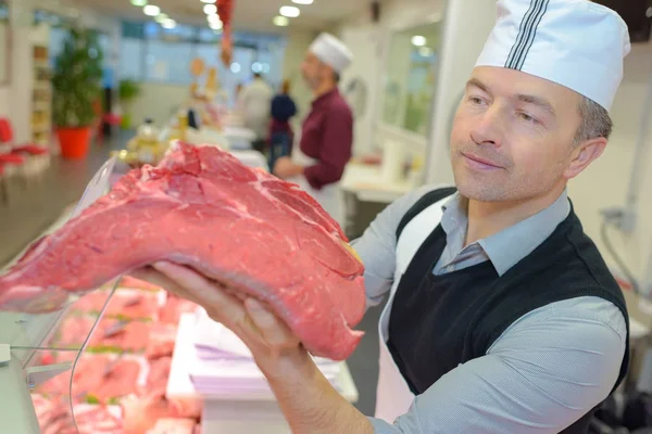 Slager houdt een groot stuk vlees — Stockfoto