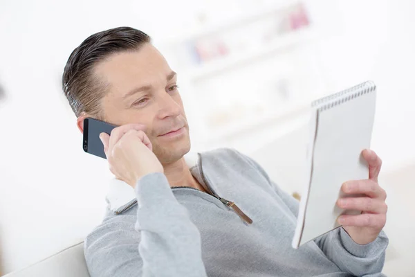 Attrayant homme d'affaires souriant prendre des notes parler au téléphone — Photo