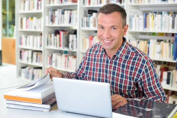 Portrét muže s knihami a laptop — Stock fotografie