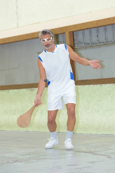 Giovane uomo caucasico giocare a squash — Foto Stock