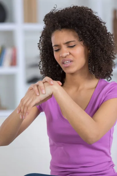 Young businesswoman suffering from wrist pain in the office — Stock Photo, Image