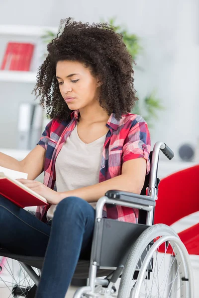 Femme en fauteuil roulant lisant un livre — Photo
