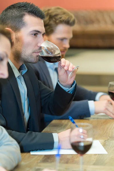 Selbstbewusster junger Mann trinkt Wein in Restaurant — Stockfoto