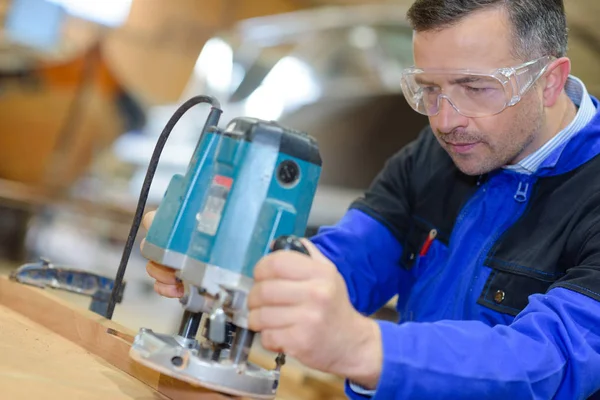 Tradesman usando roteador e homem — Fotografia de Stock