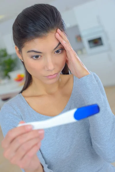 Gestresste Frau schaut auf Schwangerschaftstest — Stockfoto