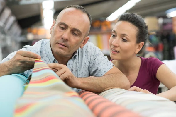 Couple choisissant un tapis tenant jusqu'à un échantillon swatch — Photo