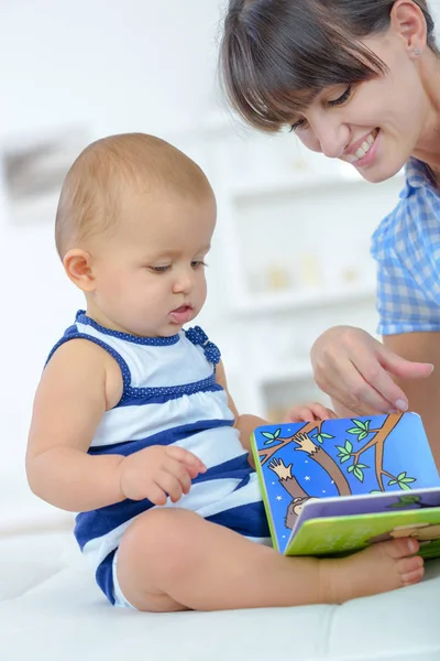 Happy mother with baby lying on bed at home — Stock Photo, Image