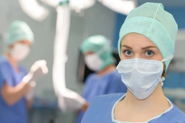 Cirurgiã feminina cercada por sua equipe — Fotografia de Stock