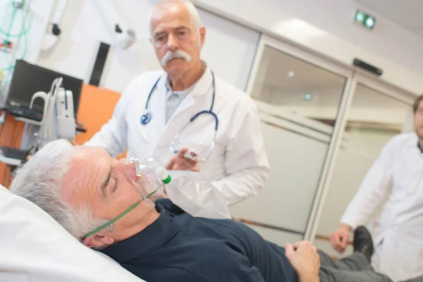 Médico aplicando máscara de oxígeno en paciente mayor — Foto de Stock