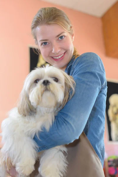 Mulher feliz e cão no salão de aliciamento — Fotografia de Stock