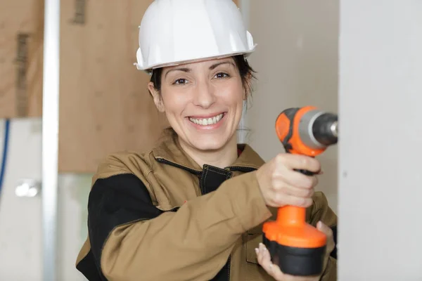 Lachende vrouw bouwer met boor gereedschap — Stockfoto