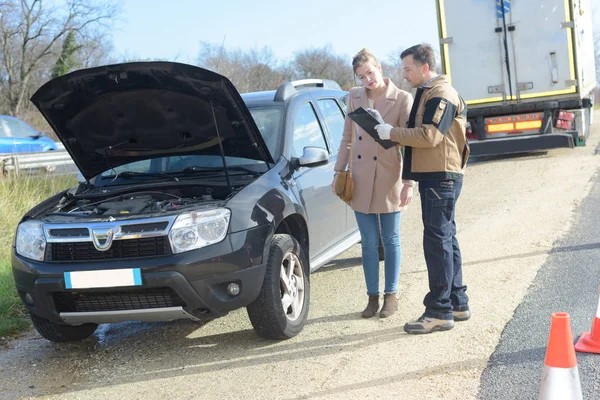 Stressed young woman breakdown with car and assistance mechanic — Stock Photo, Image