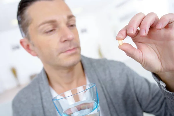 Middle aged man taking a pill — Stock Photo, Image