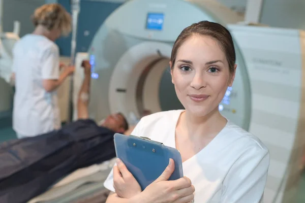 Female radiologist with colleagues standing by mri machine — Stock Photo, Image