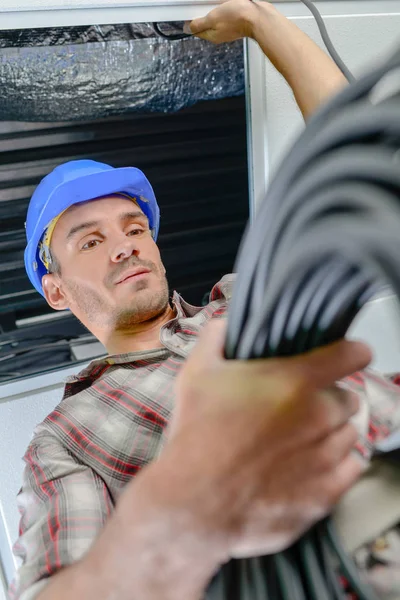 Builder innehav rulle av kabel — Stockfoto