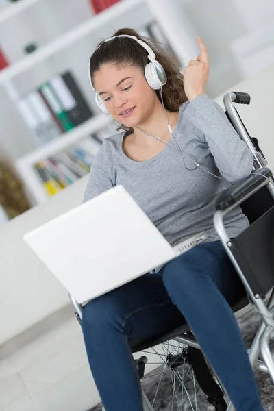 Mujer discapacitada en silla de ruedas con portátil —  Fotos de Stock