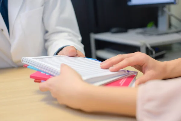 Het overhandigen van notebooks en Bureau — Stockfoto