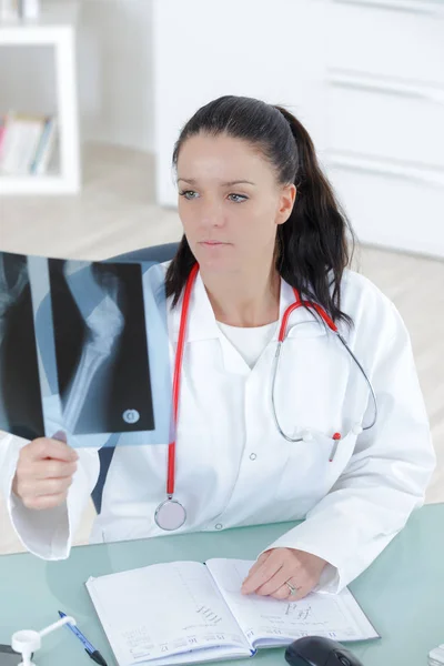 Médico olhando para a imagem de raio-x da mão — Fotografia de Stock