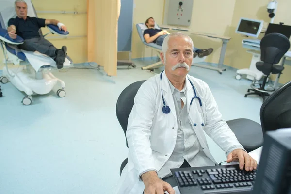 Medico anziano che lavora con il computer — Foto Stock