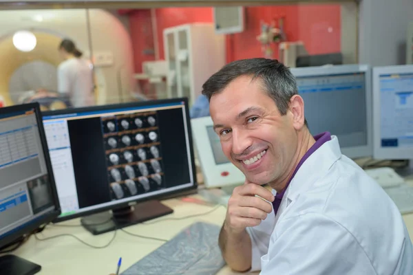 Ευτυχισμένος γιατρός εξετάζει μια αξονική τομογραφία εγκεφάλου στο pc — Φωτογραφία Αρχείου