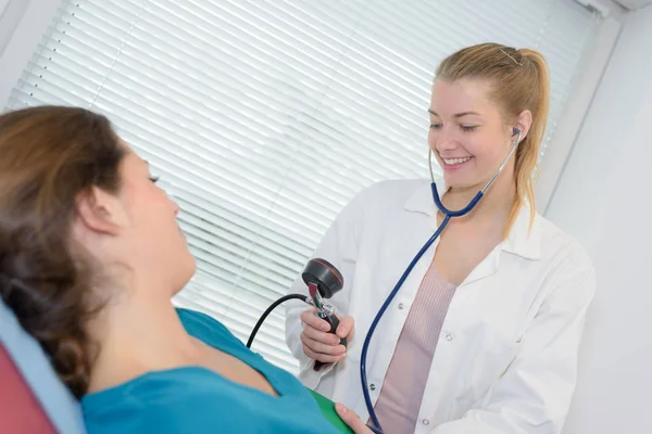 Vrouwelijke arts nemen bloeddruk — Stockfoto