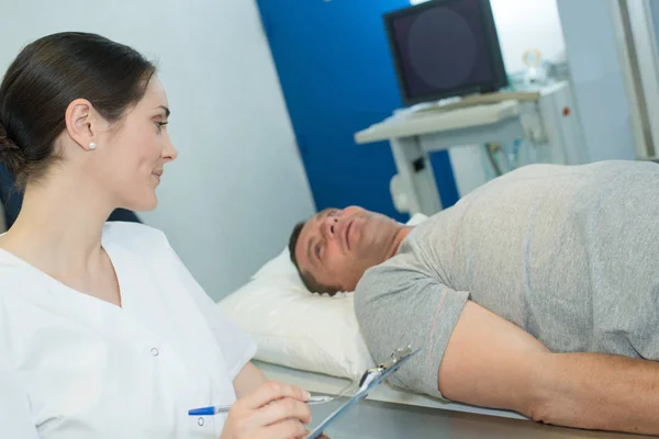 Krankenschwester spricht mit Patient auf Krankenhaustrage — Stockfoto