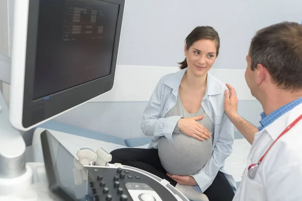 Medico con sorridente giovane donna incinta — Foto Stock