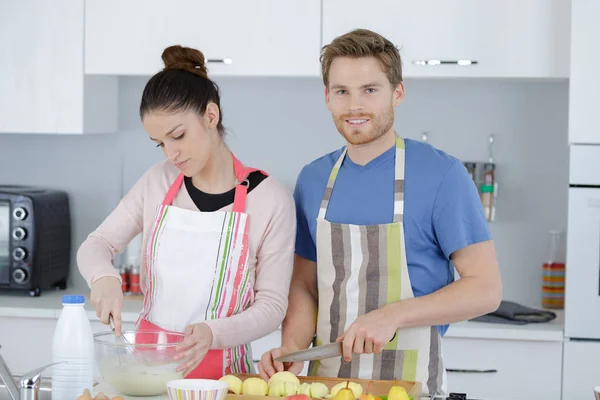 Pareja haciendo pastel de manzana en la cocina — Foto de Stock