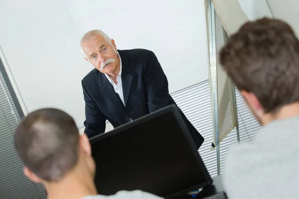 Insegnante senior con gruppo di studenti felici nella scuola moderna — Foto Stock