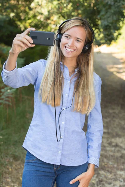 Joven activa escuchando música y haciendo selfie —  Fotos de Stock