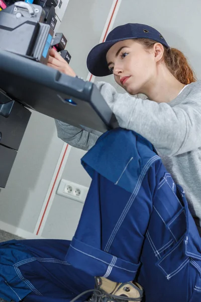 Jovem mulher reparando fotocopiadora — Fotografia de Stock