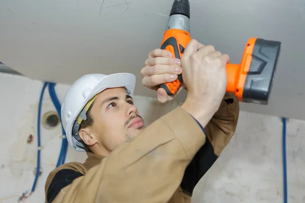 Handenarbeid boren plafond met een boormachine — Stockfoto