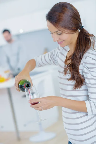 Vrouw gieten zelf een glas rode wijn — Stockfoto