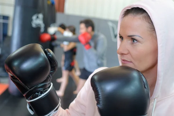 Sexy fighter girl in gym with boxing bag — Stock Photo, Image