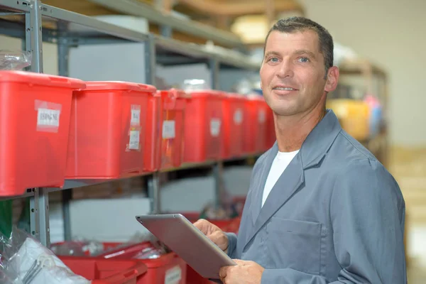 Mann im Lager hält Klemmbrett — Stockfoto