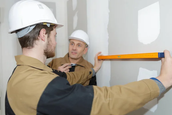 Aprendiz midiendo la superficie de la pared —  Fotos de Stock