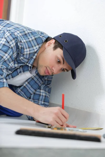 Handyman working on floor in new home - construction concept — Stock Photo, Image