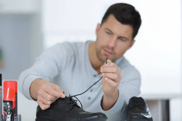 Homem bonito limpando seus sapatos — Fotografia de Stock