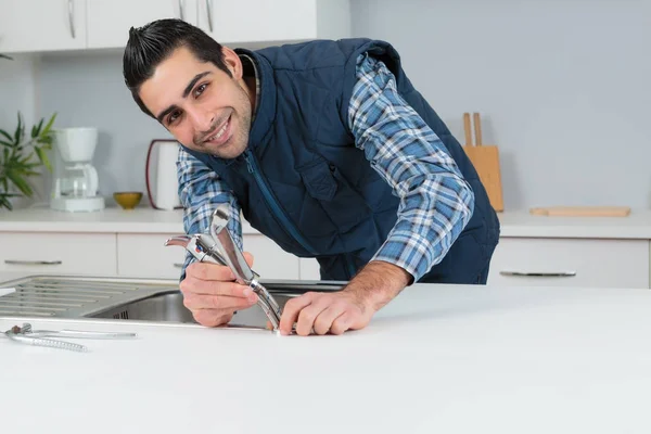Porträt eines Installateurs, der Küchenarmatur montiert — Stockfoto