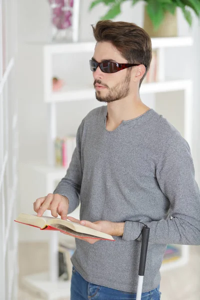Blinde man lezen van een boek van braille thuis — Stockfoto