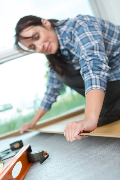 Handywoman yükleme yeni ahşap zemin — Stok fotoğraf