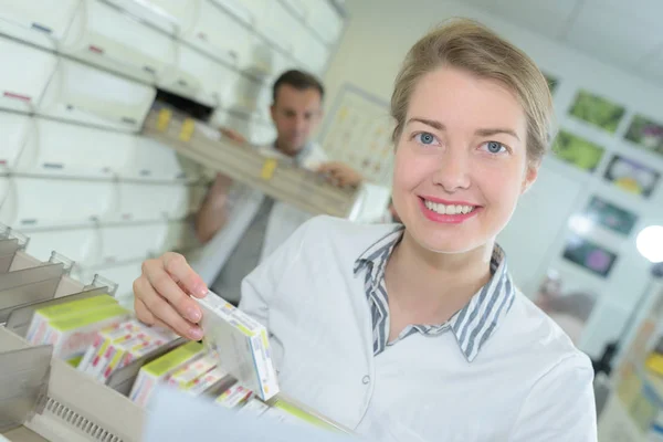 Leende attraktiva unga kvinnliga farmaceut på apoteket — Stockfoto